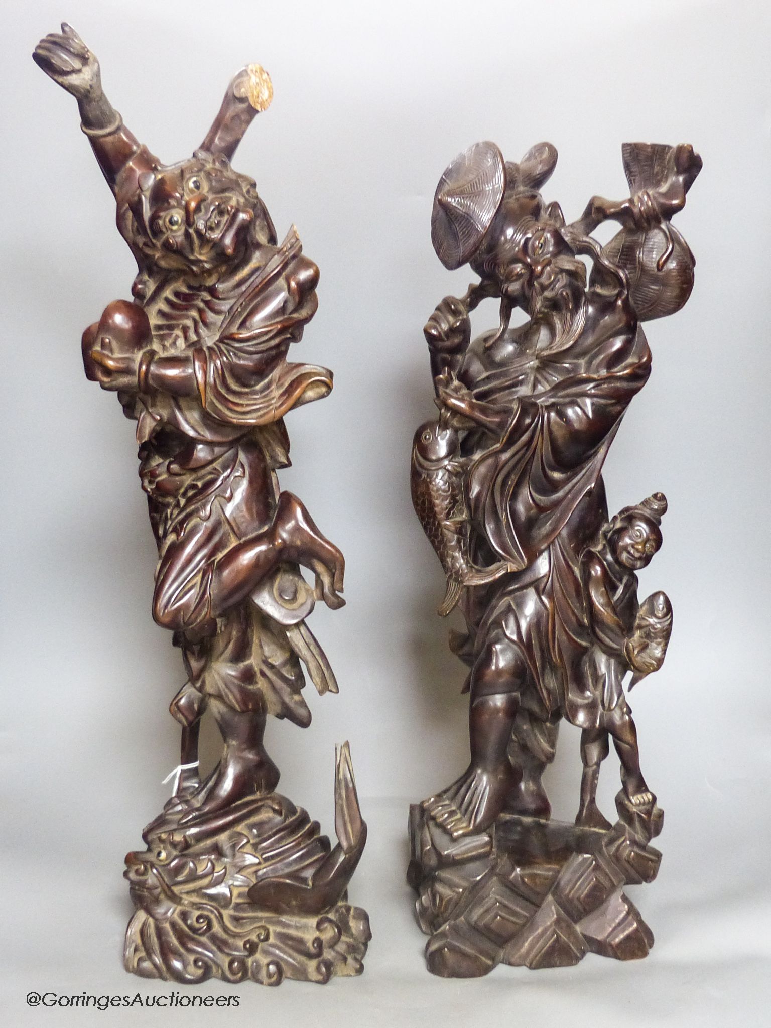 Two early 20th century Chinese hardwood figures of a demon and a fisherman, tallest 61cm